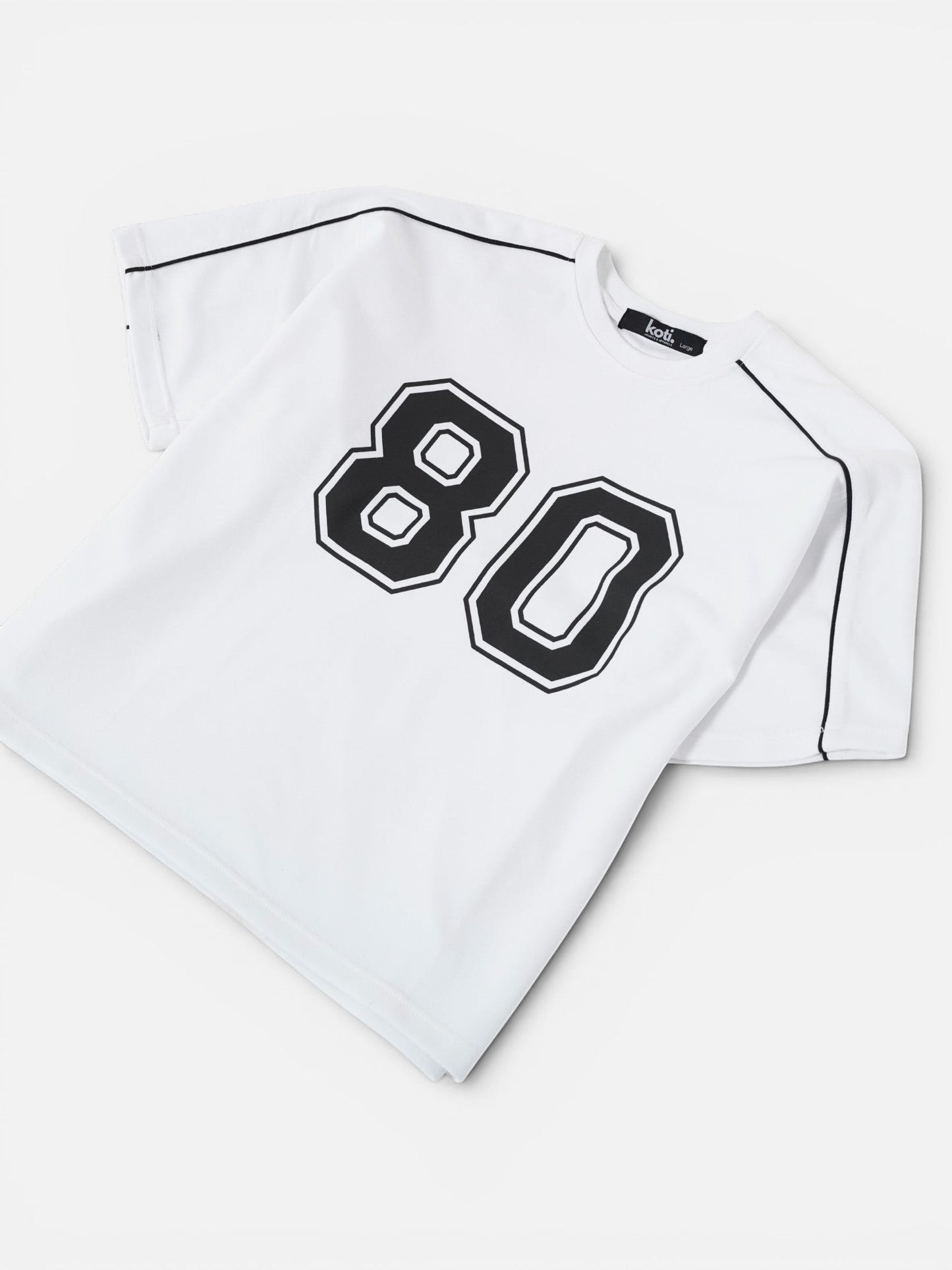 Koti Apparels white cotton blend t-shirt with black "80" graphic and black piping detail.