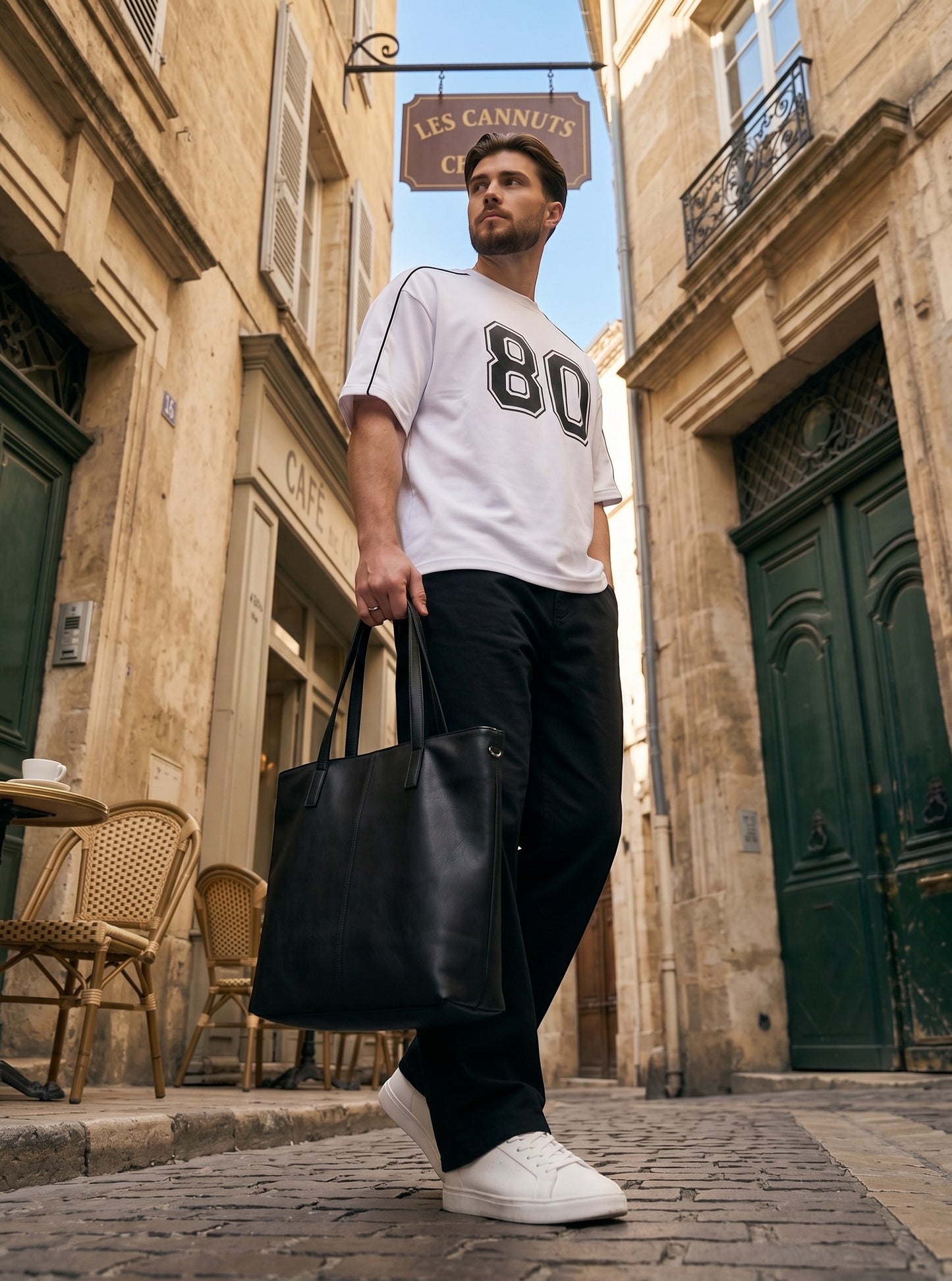 Koti Apparels white cotton down shoulder t-shirt with black 80 graphic and piping, worn by a man in a city street.